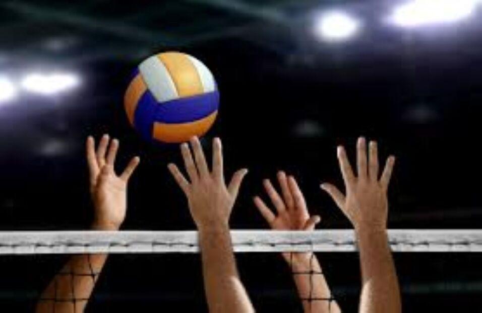 Hände greifen nach einem Volley- bzw. Volleyball über einem Netz in einer sportlichen Umgebung.