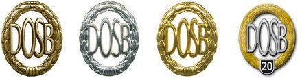 Vier farbige Medaillen mit dem Schriftzug &bdquo;DOSB&ldquo; in unterschiedlichen Ausf&uuml;hrungen: Gold, Silber, Bronze und eine Jubil&auml;umsmedaille.